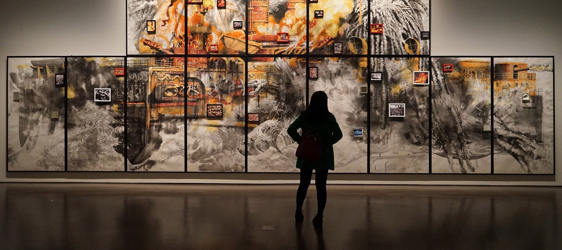 Image of a woman looking at art hanging on a wall in a museum.